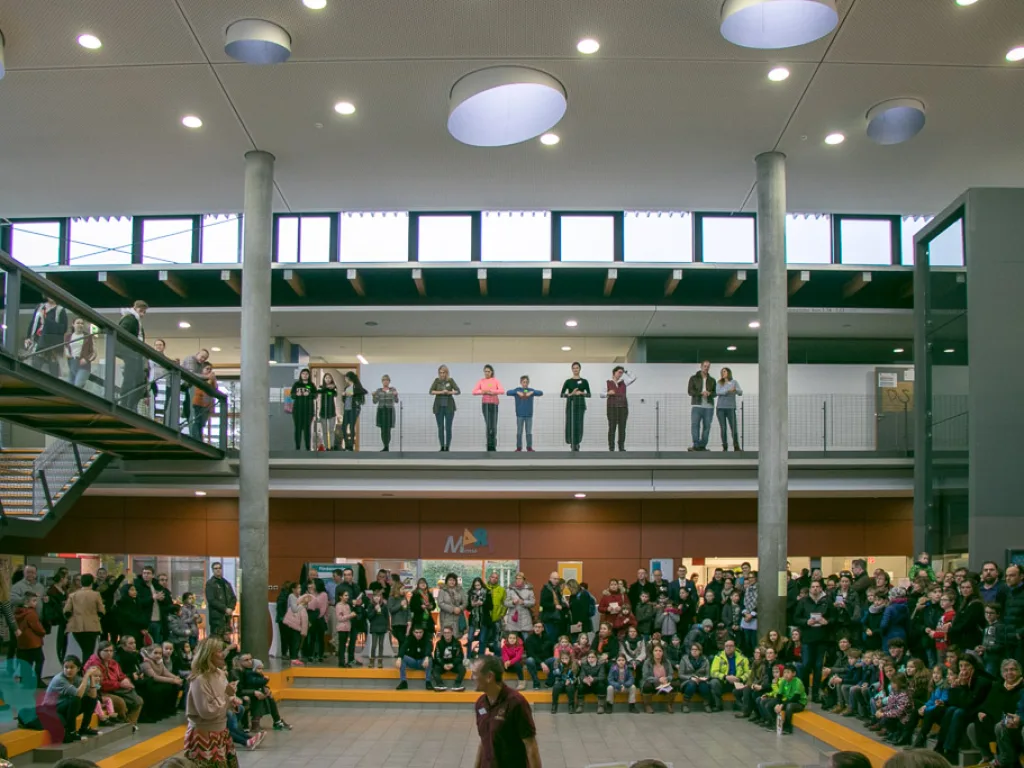 Besucher stehen auf der Galerie über dem Foyer.